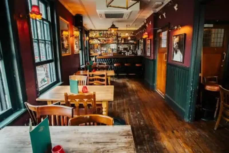 Victorian pub with a green-tiled facade, stained-glass windows and a large menu of bottled beers.